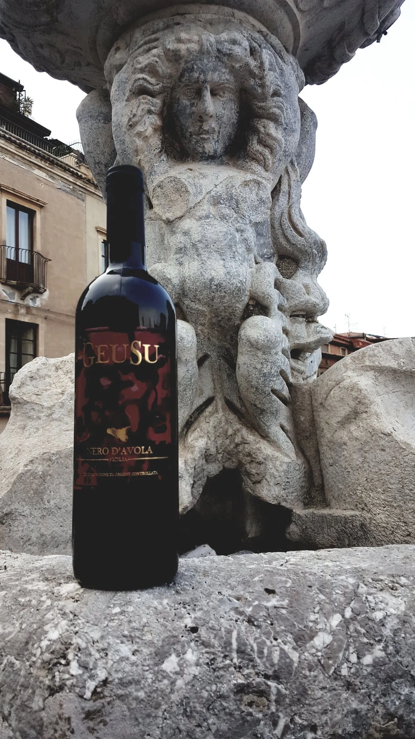 Nero d'Avola Geusu appoggiato a una scultura barocca in pietra