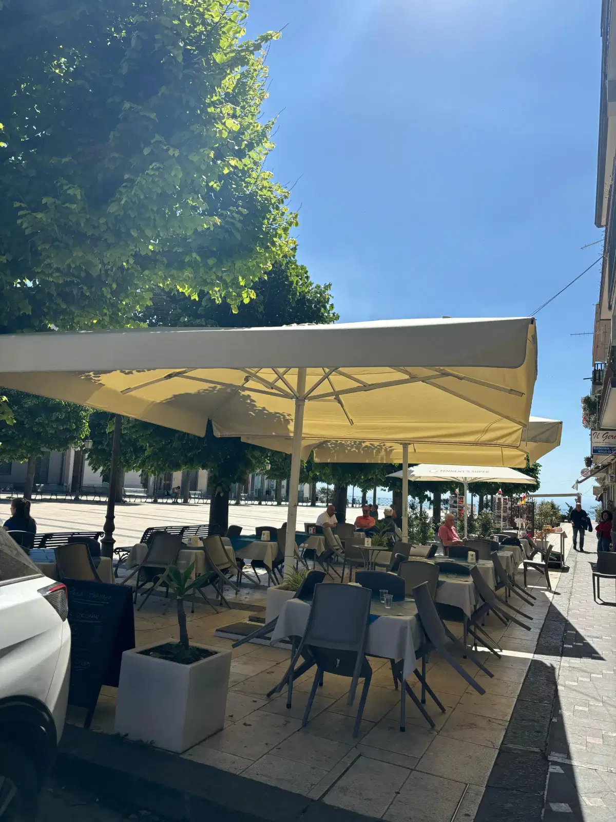 I tavoli all'aperto sotto gli ombrelloni, sulla piazza