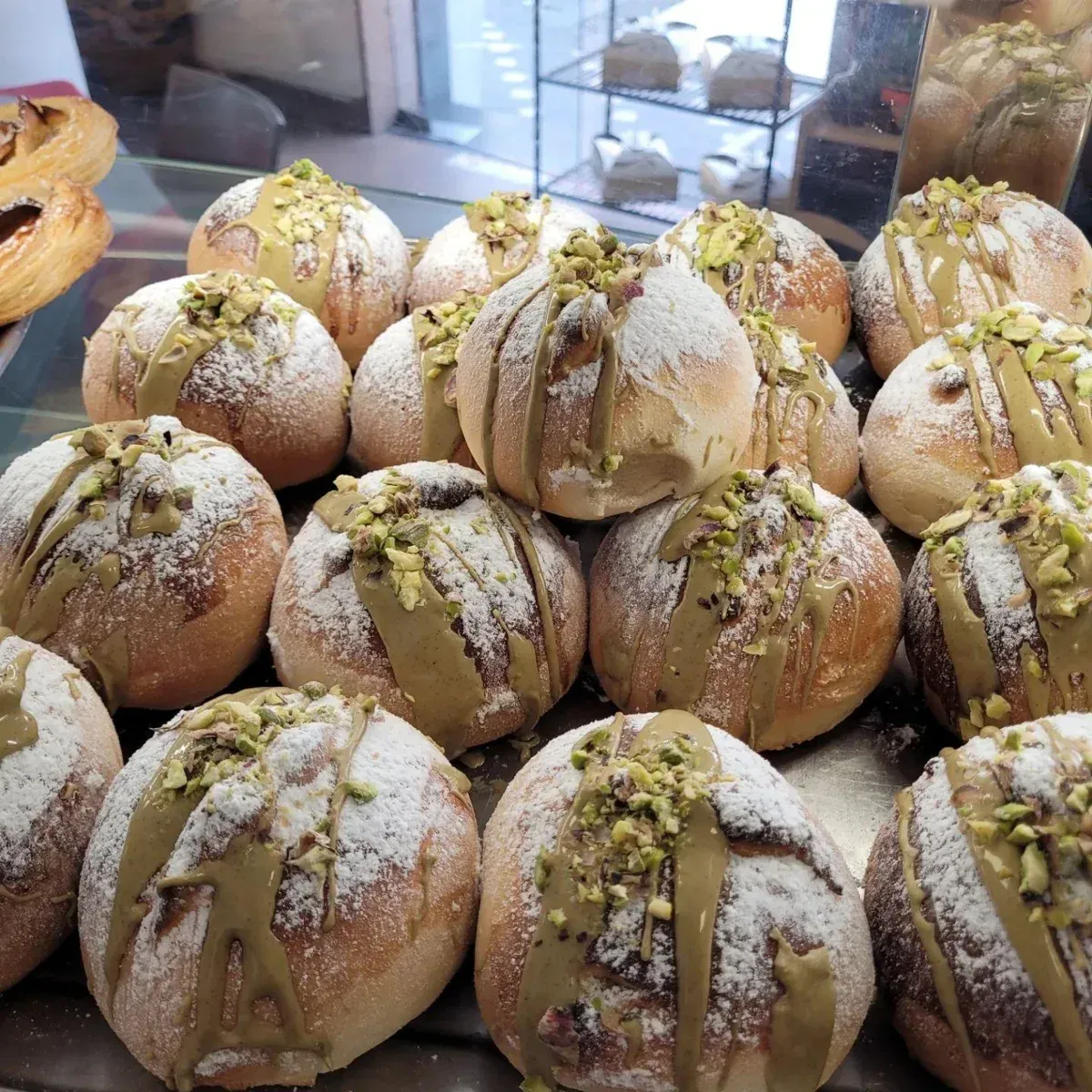 Brioche ripiene al pistacchio nella vetrina del bar