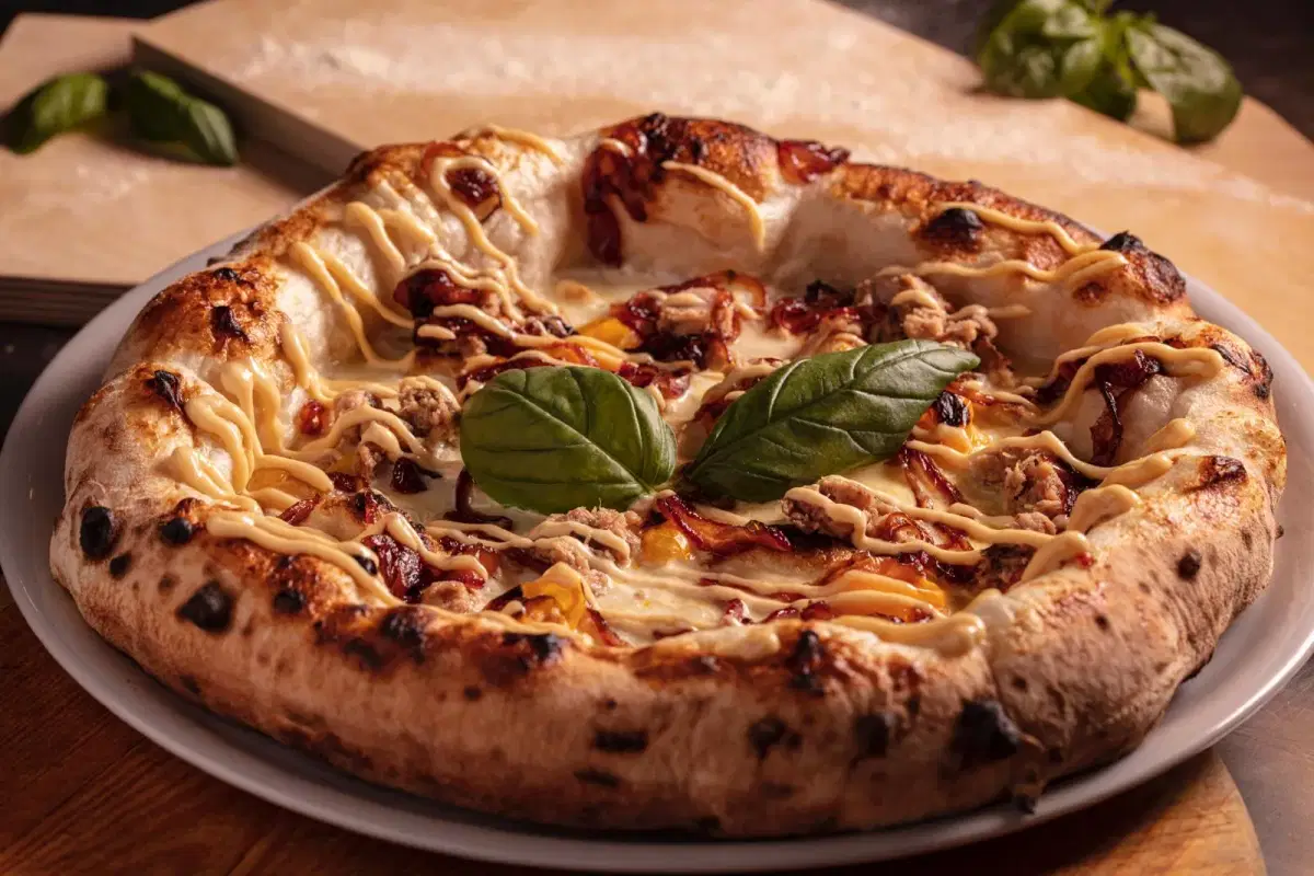 Pizza gourmet con cipolla caramellata, salsiccia e basilico