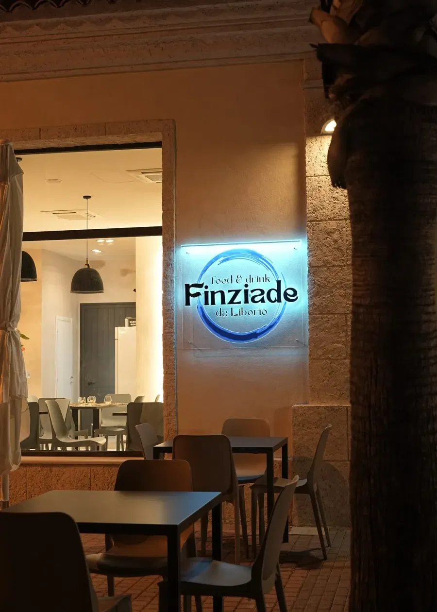 L'insegna luminosa di Finziade all'ingresso, di sera