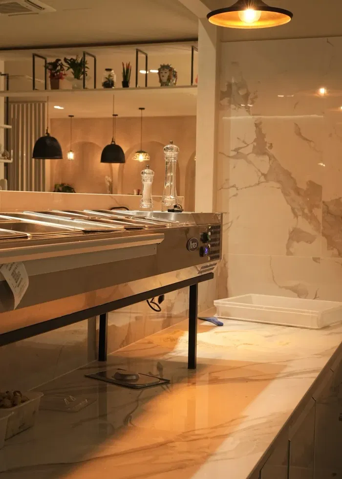 Il banco di marmo della pizzeria con le luci calde