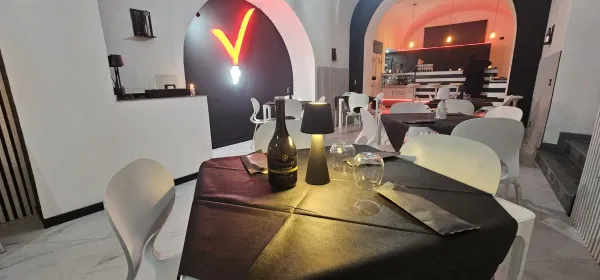 La sala con i tavoli e la V rossa accesa