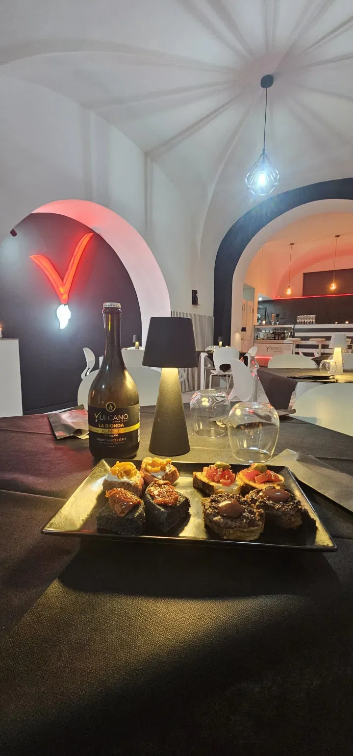 Vistrò's vaulted dining room with the red V lit up
