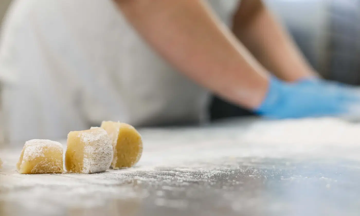 Pezzi di impasto appena tagliati sul banco infarinato del laboratorio