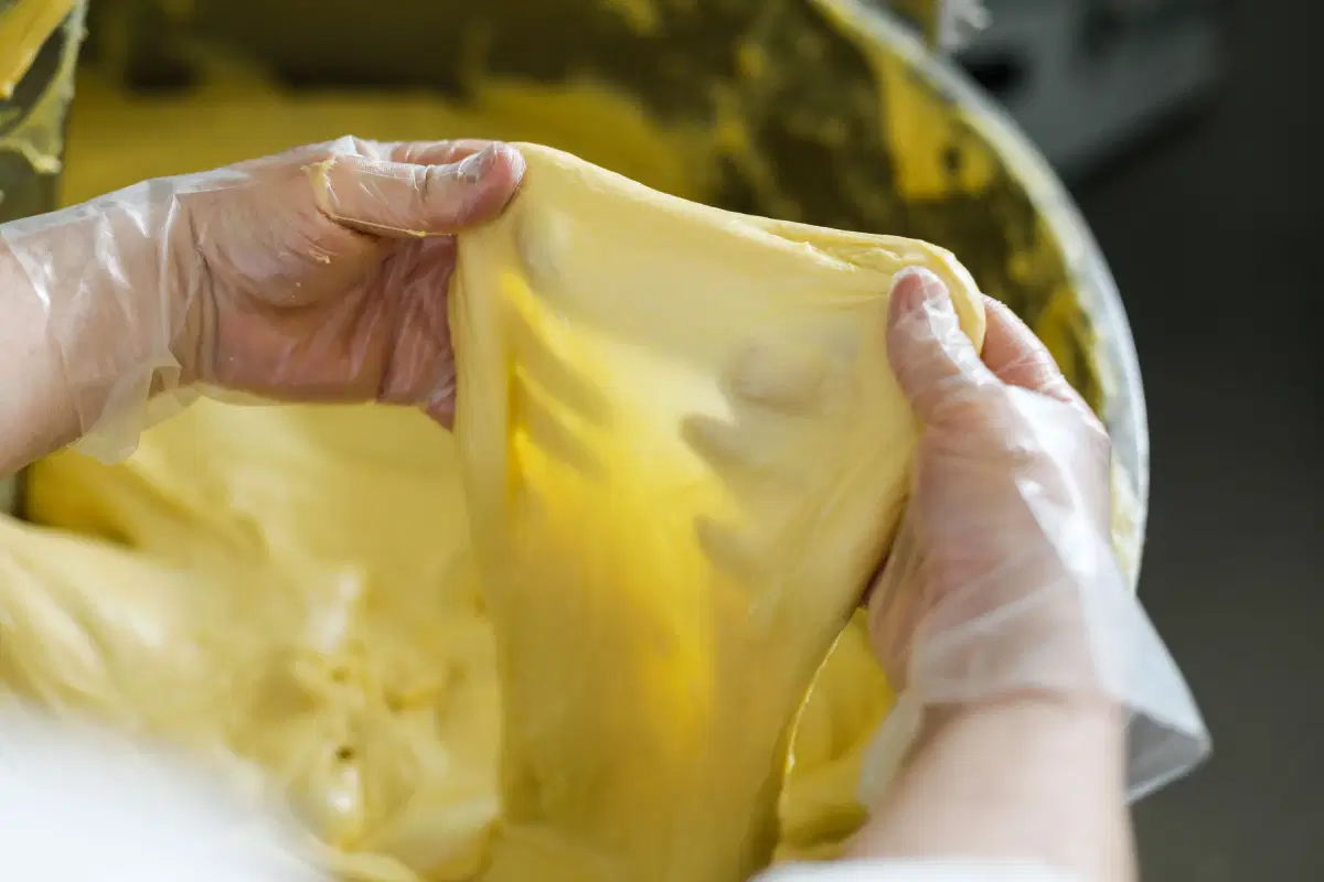 Mani che tirano l&rsquo;impasto fino a farne un velo
