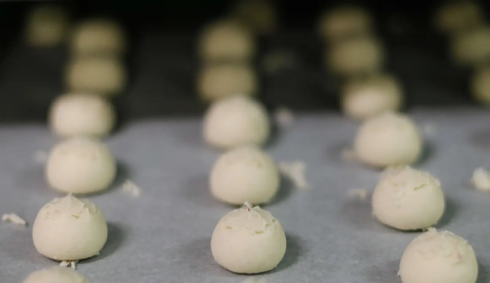 Paste di mandorla in fila sulla teglia, in attesa del forno